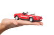 Close-up of red toy car on female’s palm