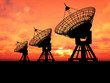 Three satelite dishes over sunset