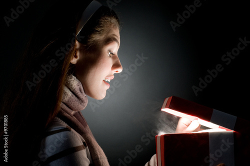 Photo: a beautifull girl opening x-mass magic present a beautifull girl opening x-mass magic present