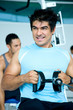 man at the gym doing back machine weight training
