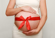Pregnant belly with red ribbon