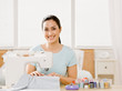 Self-sufficient woman using sewing machine to make clothing