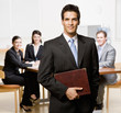 Businessman with notebook and co-workers in conference room