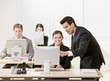 Co-worker listening to supervisor explain problem on computer