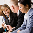 Businesswoman handing co-worker business card in meeting