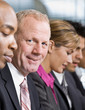 Photo: Close up of multi-ethnic co-workers sitting in a row Close up of multi-ethnic co-workers sitting in a row