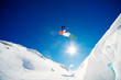 Snowboarder jumping through the air with blue sky background
