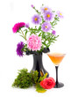 black vase with colors and green moss with scarlet rose