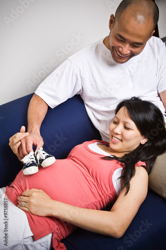 Photo: A shot of a father and mother with her unborn baby's shoes A shot of a father and mother with her unborn baby's shoes