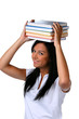 Junge Frau mit einem Bücherstapel am Kopf