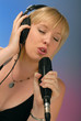 cute blond girl singing with microphone & headphones