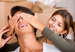 couple having fun at home where she is covering his eyes