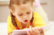Photo en ligne au meilleur prix Cute little girl reading a book