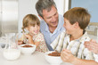 Photo: Father Sitting With Children As They Eat Breakfast Father Sitting With Children As They Eat Breakfast