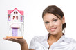 Portrait of young woman holding toy house