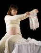 happy pregnant woman portrait with baby clothes in hands