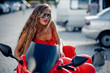 Beautiful woman in red posing on motorcycle