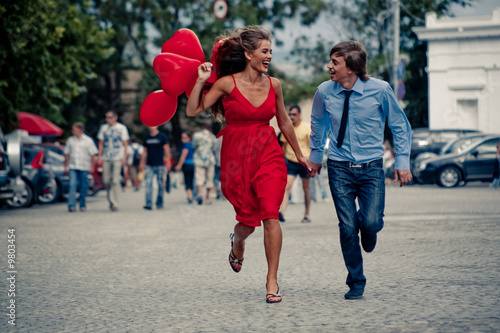 Photo: Runnng happy teenage couple in street Runnng happy teenage couple in street