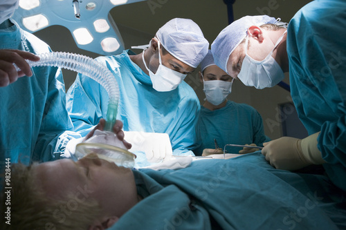 Three Surgeons Operating On A Patient