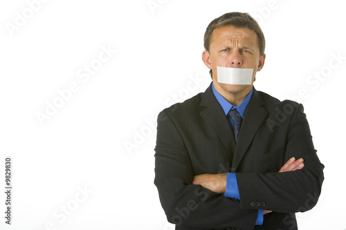 Photo: Businessman With His Arms Folded And His Mouth Taped Shut Businessman With His Arms Folded And His Mouth Taped Shut