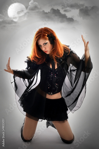 Photo: Portrait of a young beautiful witch in the black dress Portrait of a young beautiful witch in the black dress