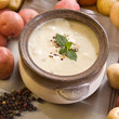A bowl of freshly made creamy potato soup garnished with mint A bowl of freshly made creamy potato soup garnished with mint
