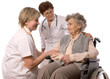 Health care workers and elderly woman in wheelchair