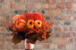 A colorful red and orange bridal bouquet of flowers