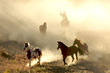 Sunlight Horses and cowboy galloping and through the desert Sunlight Horses and cowboy galloping and through the desert