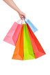 Woman hand holding several shopping bags isolated on white.