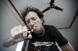 Young man lighting up a cigarette in hotel room