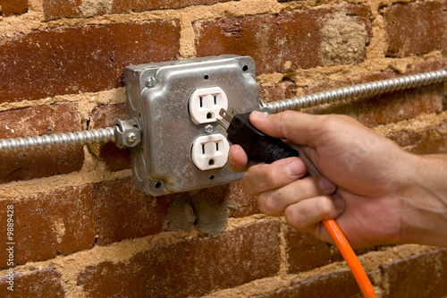 Photo: a man's hand plugging in an extension cord a man's hand plugging in an extension cord