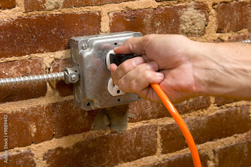 Photo: a man's hand plugging in an cord in a man's hand plugging in an cord in