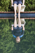 Young boy sitting on a diving board.