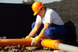 Plumber assembling pvc sewage pipes in house foundation