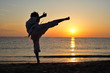 Foto: Young boy in karate uniform training at sunset Young boy in karate uniform training at sunset