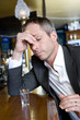 A depressed man with a shot of vodka