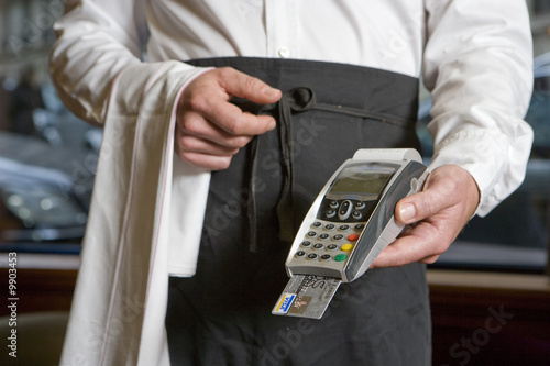 Photo: A waiter with a payment machine A waiter with a payment machine