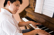 Photo: A shot of an asian man playing piano A shot of an asian man playing piano