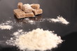 Brown sugar cubes and flour on black surface