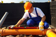 Plumber measuring slope of assembled sewage pipes