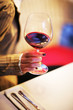 Female hand with glass of red wine. Shallow DOF.