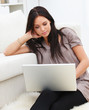Young woman using laptop and sitting at home