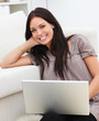 Closeup of a young woman using laptop at home