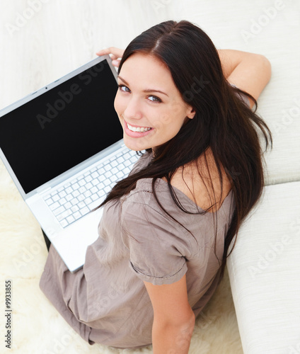 Photo: Young woman sitting on floor with a laptop Young woman sitting on floor with a laptop