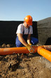 Plumber assembling pvc sewage pipes in house foundation