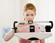 Serious woman weighing herself on scale