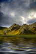 Mountains reflected in water with dramatic sky