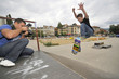 Man taking photo of boy skating in park