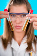 young female doctor holding two chemical tubes, focus on tube